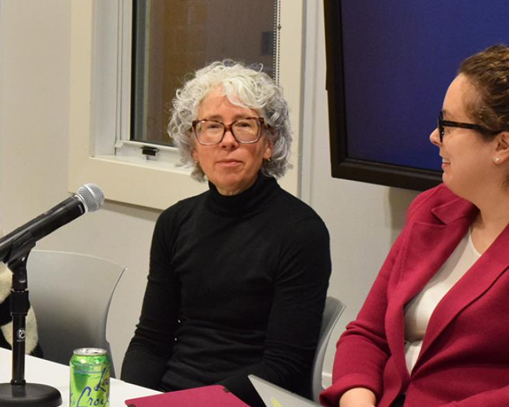 People sitting at a table with a microphone.